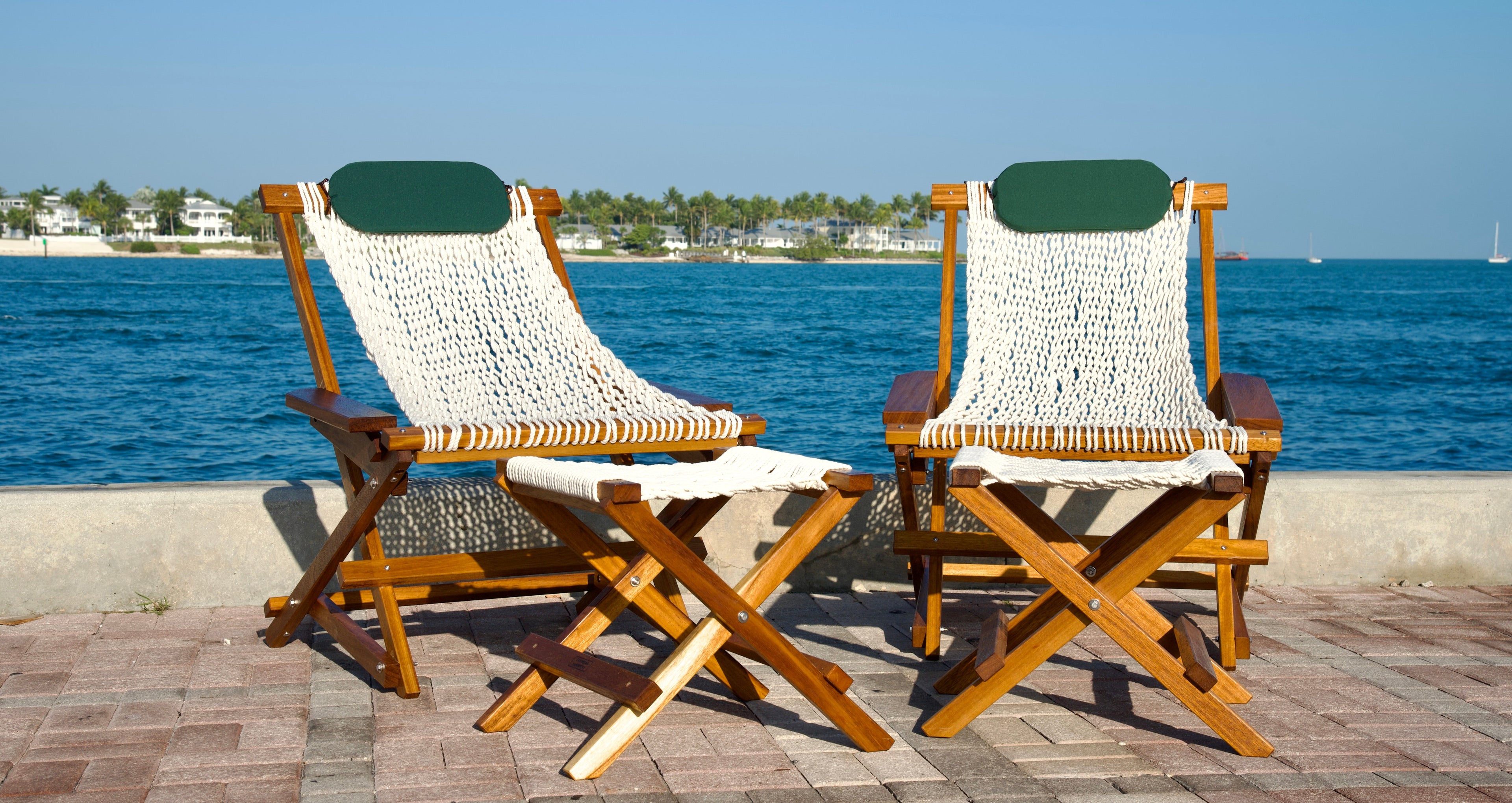 two cozy looking chairs with footrests by the gulf of america