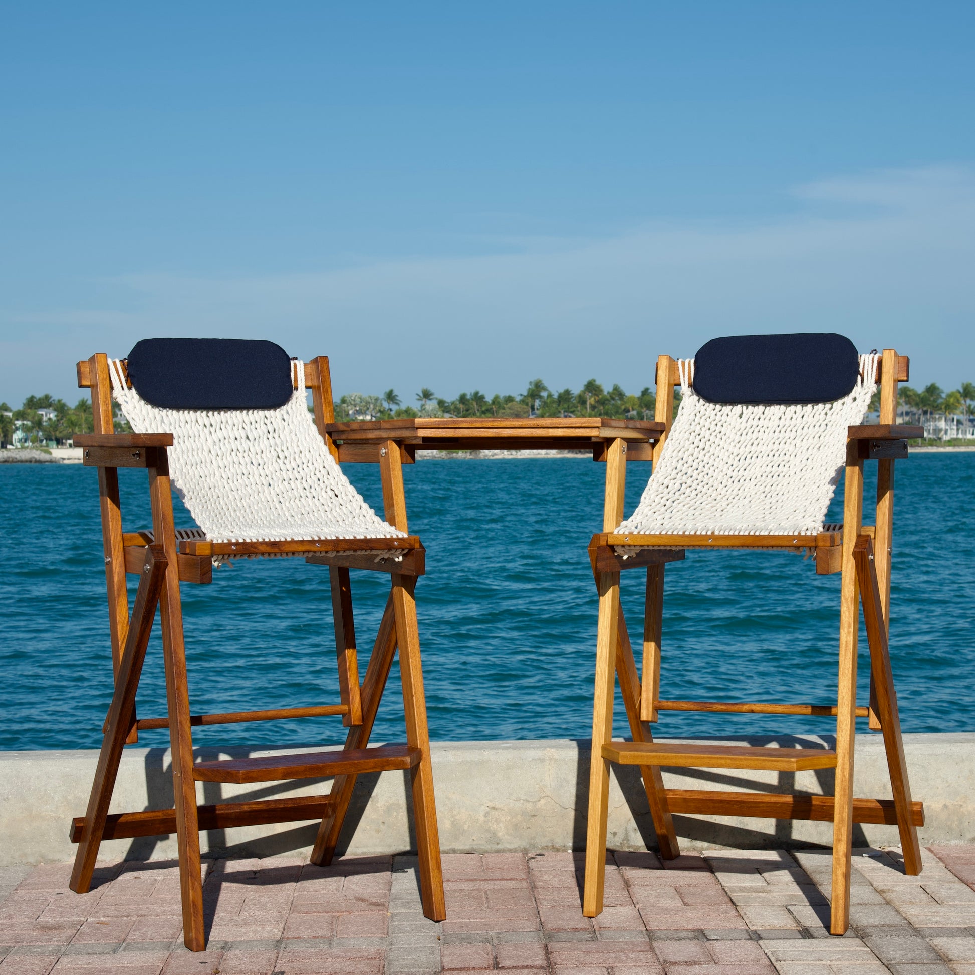 wood bar set on the dock with blue pillows and iroko wood