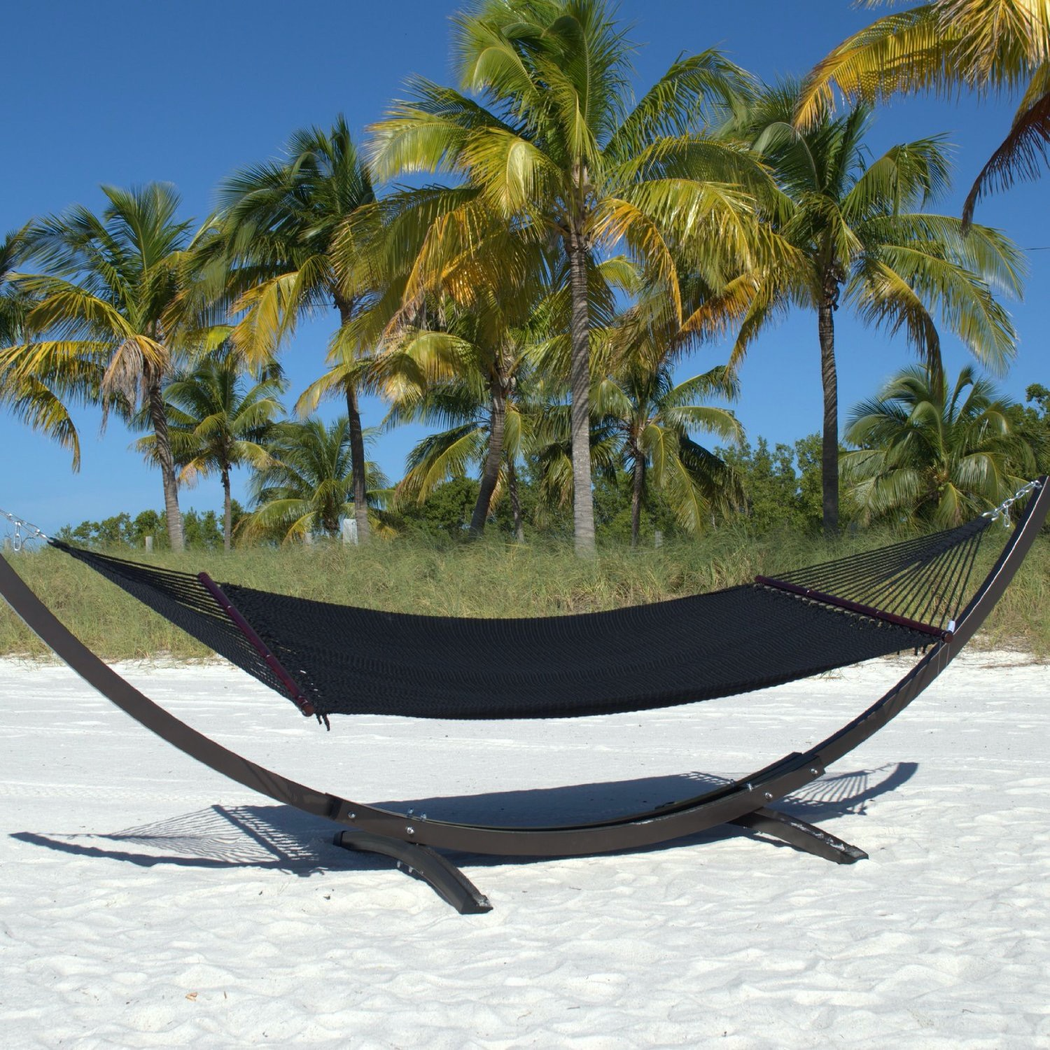 Black Double Caribbean Hammock hanging on the Wood Arc Hammock Stand on a palm-lined beach