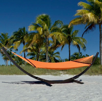 Orange Double Caribbean Hammock hanging on the Wood Arc Hammock Stand on a palm-lined beach