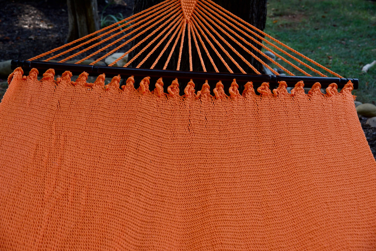 End cords fanning above the hardwood spreader bar of the Orange Double Caribbean Hammock
