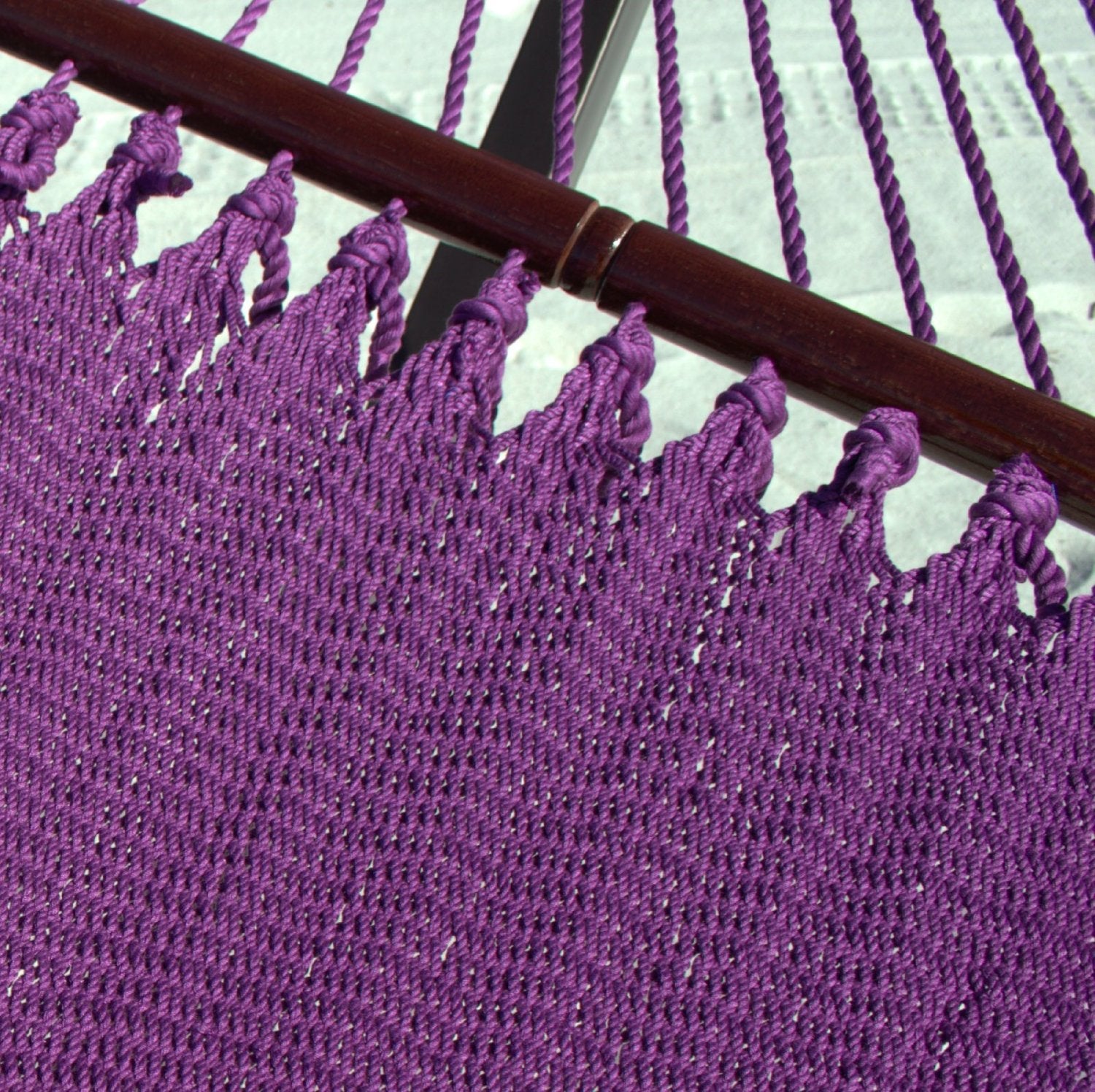 Close-up of the varnished hardwood spreader bar and end cords on the Purple Double Caribbean Hammock