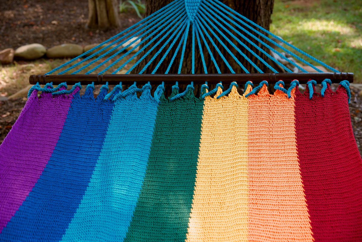 Light blue end cords fanning above the hardwood spreader bar of the Rainbow Double Caribbean Hammock