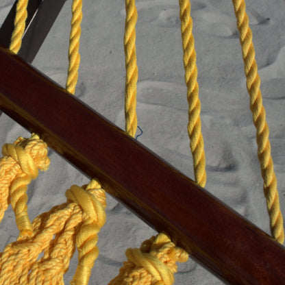Close-up of the varnished hardwood spreader bar and end cords on the Yellow Double Caribbean Hammock