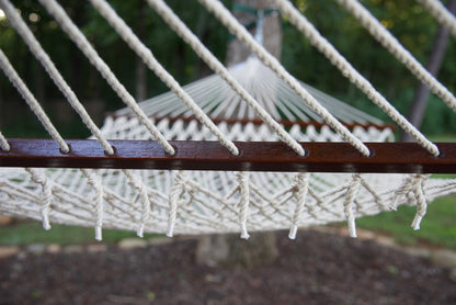 Hardwood spreader bar on a cream Island Escape hammock with suspension cords above and knotted cord ends below