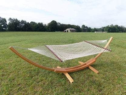Cream Island Escape hammock hanging on the Wood Arc Hammock Stand in a mown field