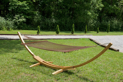 Mocha Island Escape hammock hanging on the Wood Arc Hammock Stand on a lawn beside a gravel path