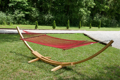 Red Island Escape hammock hanging on the Wood Arc Hammock Stand on a lawn beside a gravel path