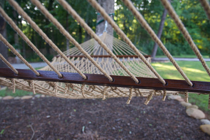 Polyester cords threaded through the drilled hardwood spreader bar of a tan Island Escape hammock