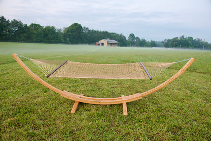 Tan Island Escape hammock hanging on the Wood Arc Hammock Stand in a misty field with a barn behind