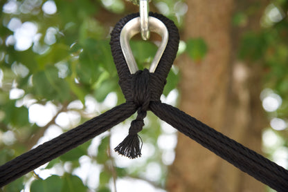 Close-up of the zinc-plated hanging ring where the black end cords of an Island Haven hammock chair meet