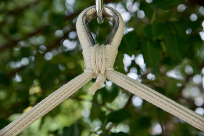 Close-up of the zinc-plated hanging ring where the cream end cords of an Island Haven hammock chair meet