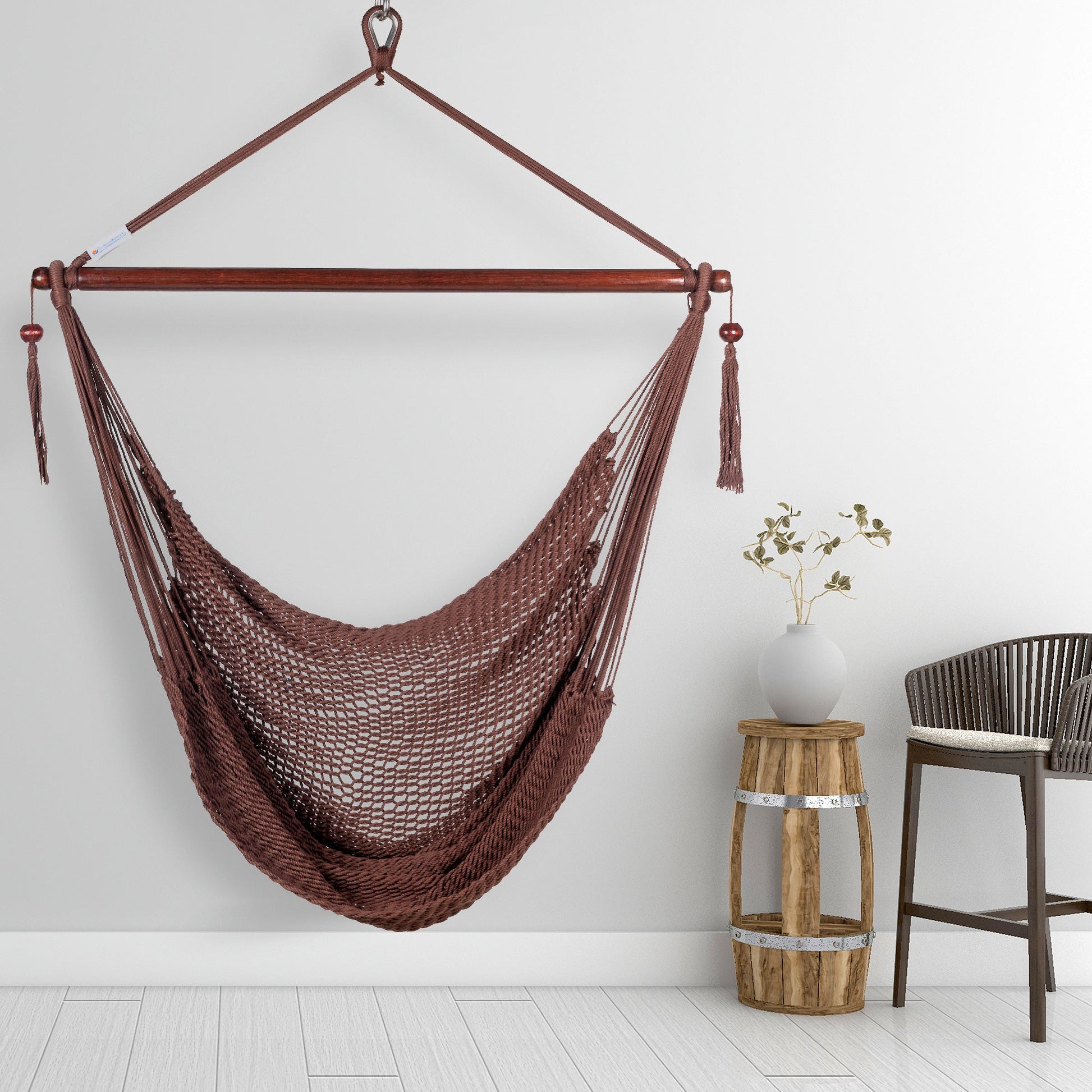 Mocha Island Haven hammock chair hanging beside a barrel side table and bar stool against a pale grey wall