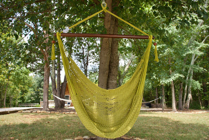 Olive Island Haven hammock chair hanging from a shade tree in a mown backyard with woods behind