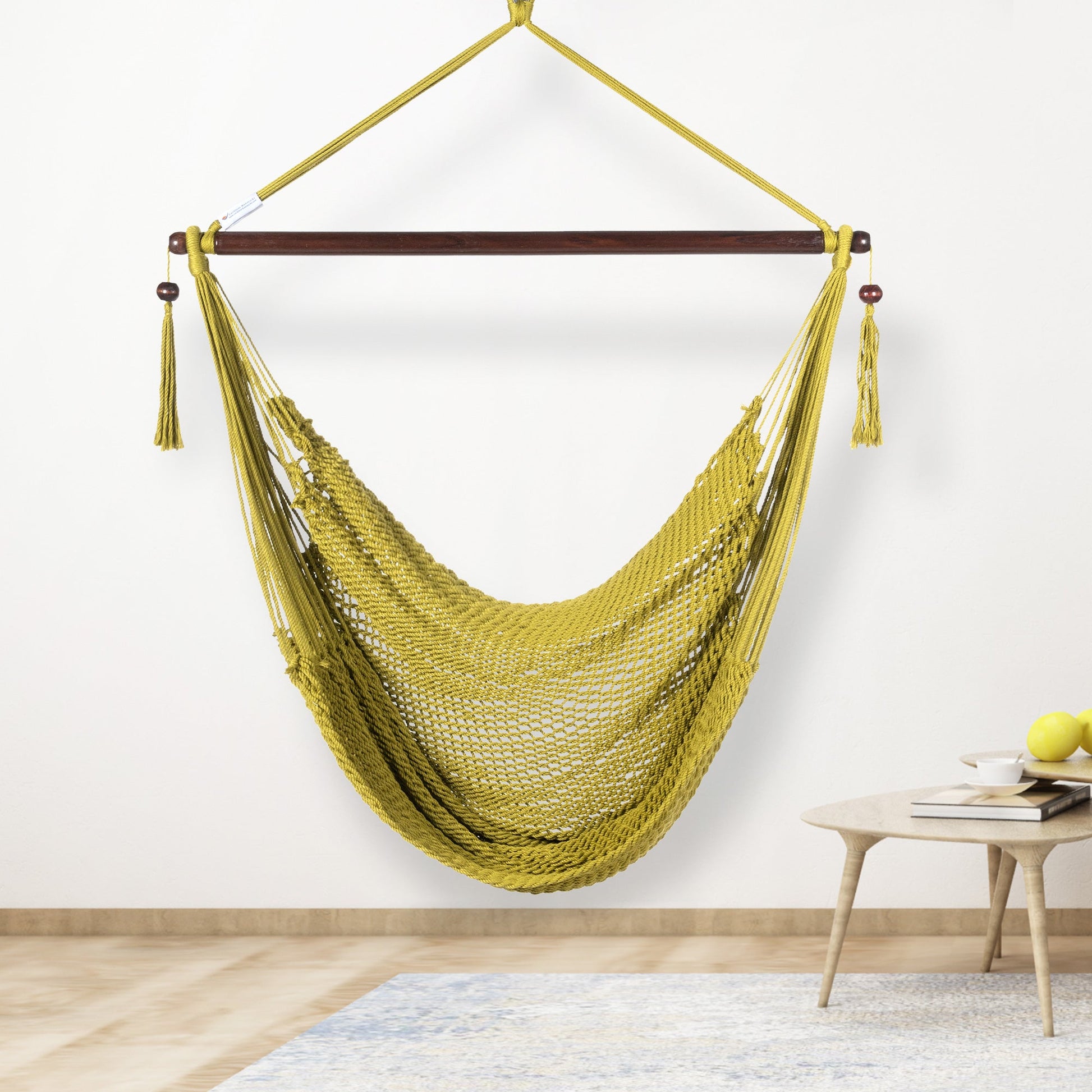 Olive Island Haven hammock chair hanging beside a barrel side table and bar stool against a pale grey wall