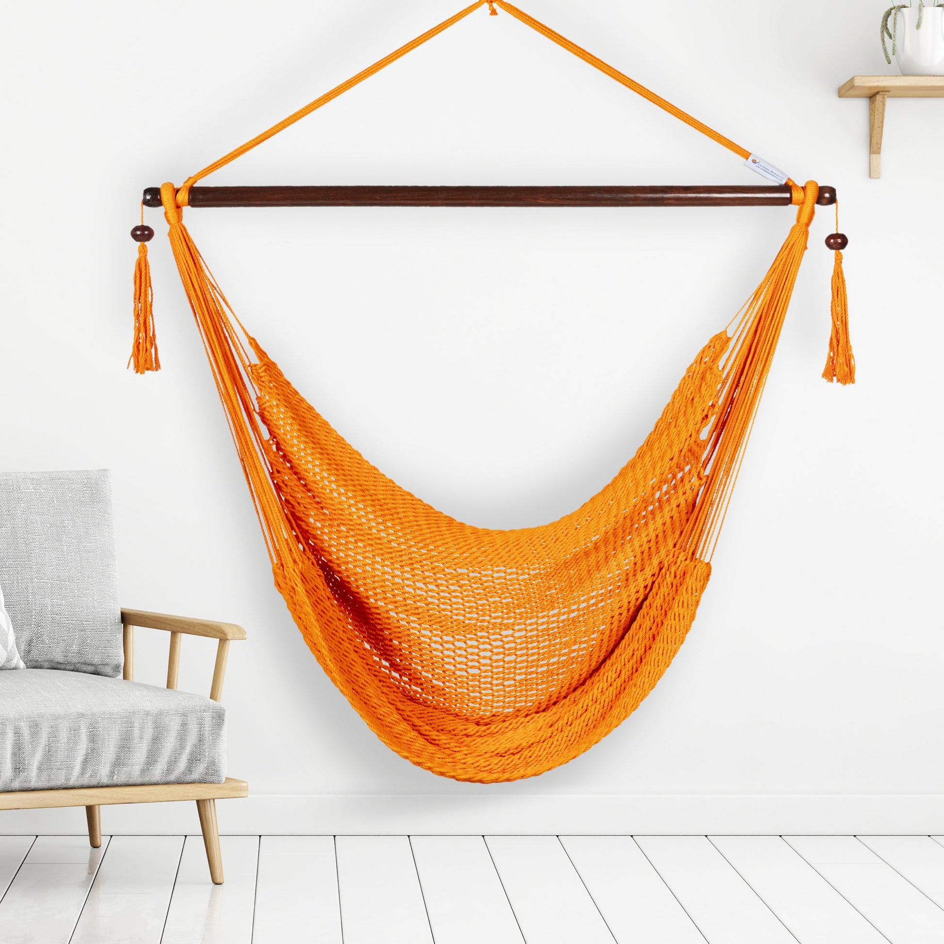 Orange Island Haven hammock chair hanging beside a barrel side table and bar stool against a pale grey wall