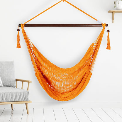 Orange Island Haven hammock chair hanging beside a barrel side table and bar stool against a pale grey wall