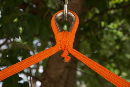 Close-up of the zinc-plated hanging ring where the orange end cords of an Island Haven hammock chair meet