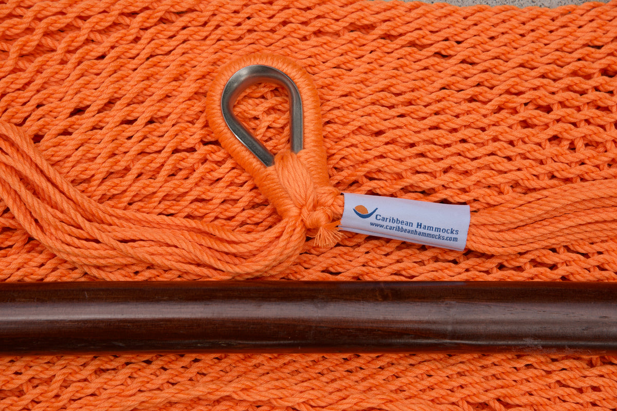 Close-up of the sewn brand label and zinc-plated ring at the seat edge of an orange Island Haven hammock chair