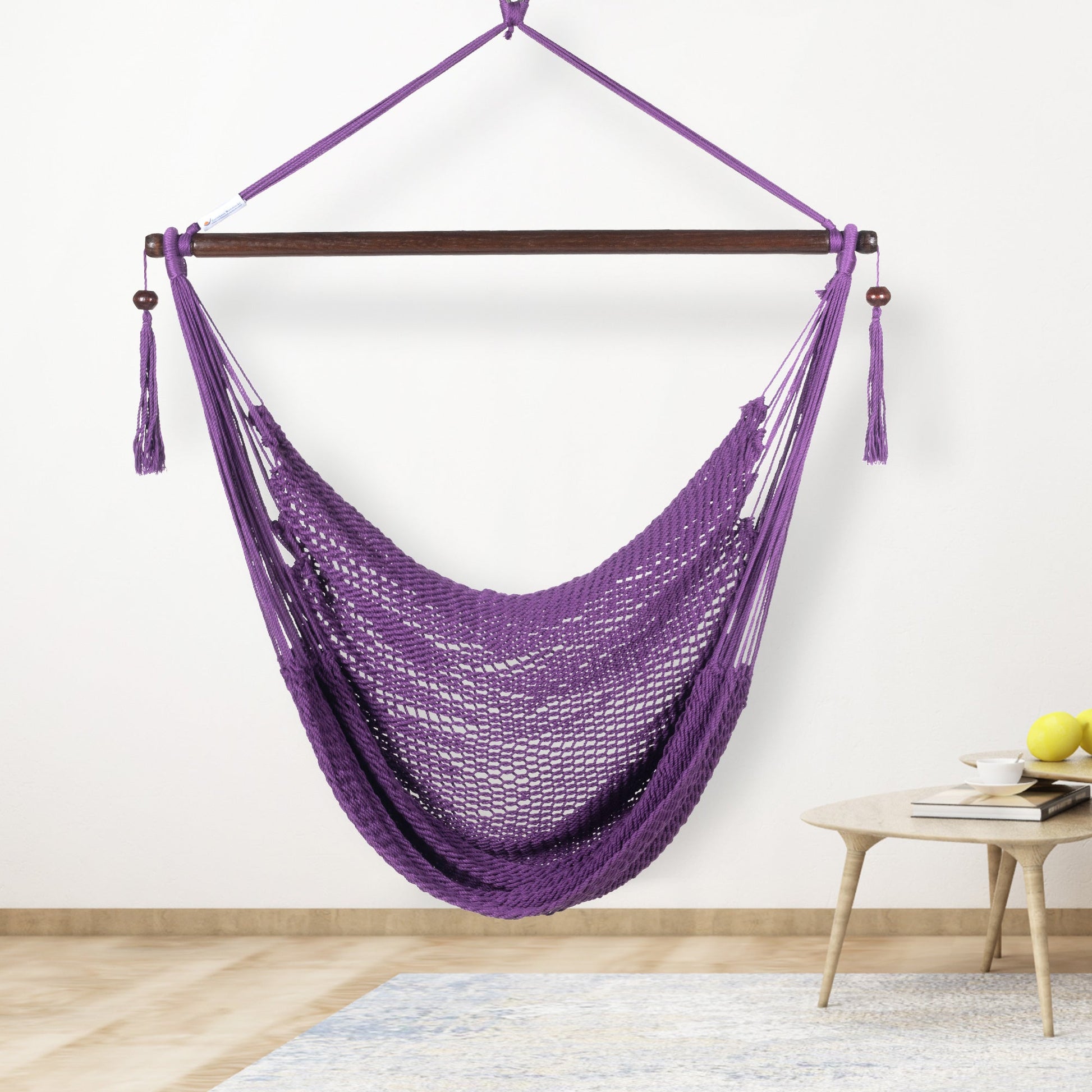 Purple Island Haven hammock chair hanging beside a barrel side table and bar stool against a pale grey wall