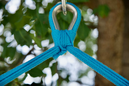Close-up of the zinc-plated hanging ring where the blue end cords of a rainbow-striped Island Haven hammock chair meet