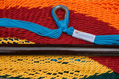 Close-up of the sewn brand label and zinc-plated ring at the seat edge of a rainbow-striped Island Haven hammock chair