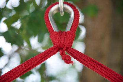Close-up of the zinc-plated hanging ring where the red end cords of an Island Haven hammock chair meet
