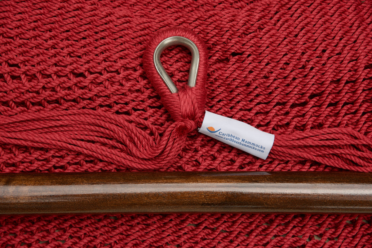 Close-up of the sewn brand label and zinc-plated ring at the seat edge of a red Island Haven hammock chair