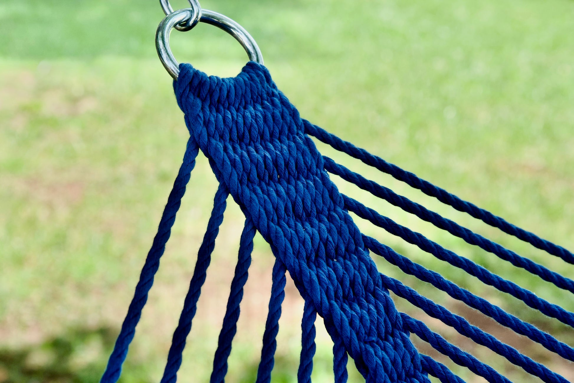 Stainless steel hanging ring, polyester end cords, and clew knot on a dark blue Island Oasis hammock, lawn behind