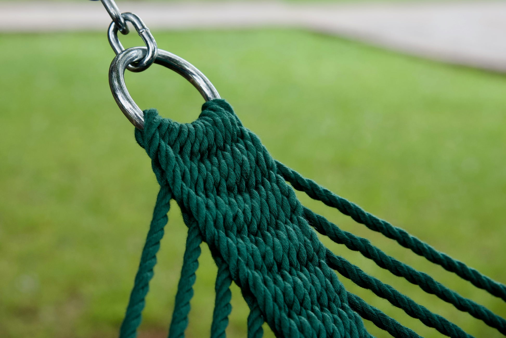 Stainless steel hanging ring, polyester end cords, and clew knot on a green Island Oasis hammock, lawn behind
