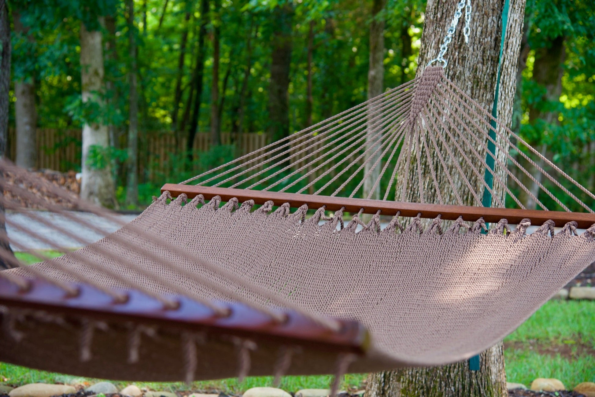 Mocha Island Oasis hammock hung between two trees in a wooded backyard