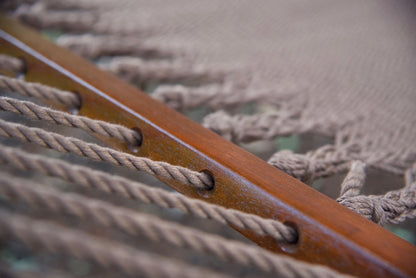 Polyester cords threaded through the drilled hardwood spreader bar of a mocha Island Oasis hammock