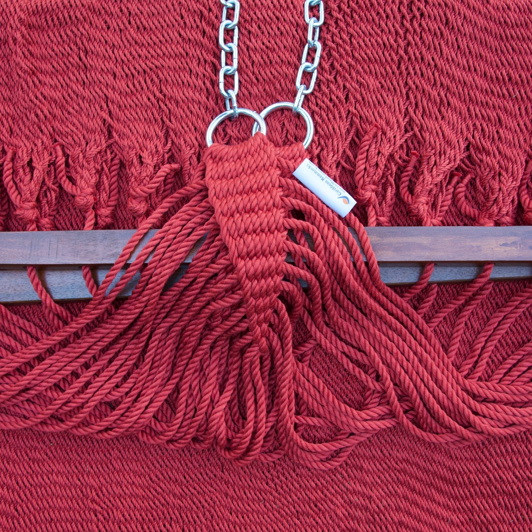 Clew knot on a red Island Oasis hammock, polyester cords gathered into stainless steel rings with hanging chain and Caribbean Hammocks label