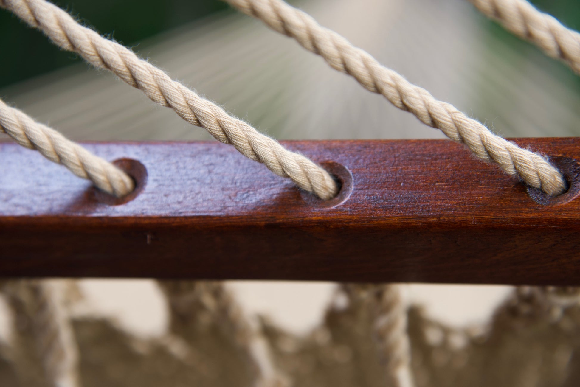 Polyester cords threaded through the drilled hardwood spreader bar of a tan Island Oasis hammock