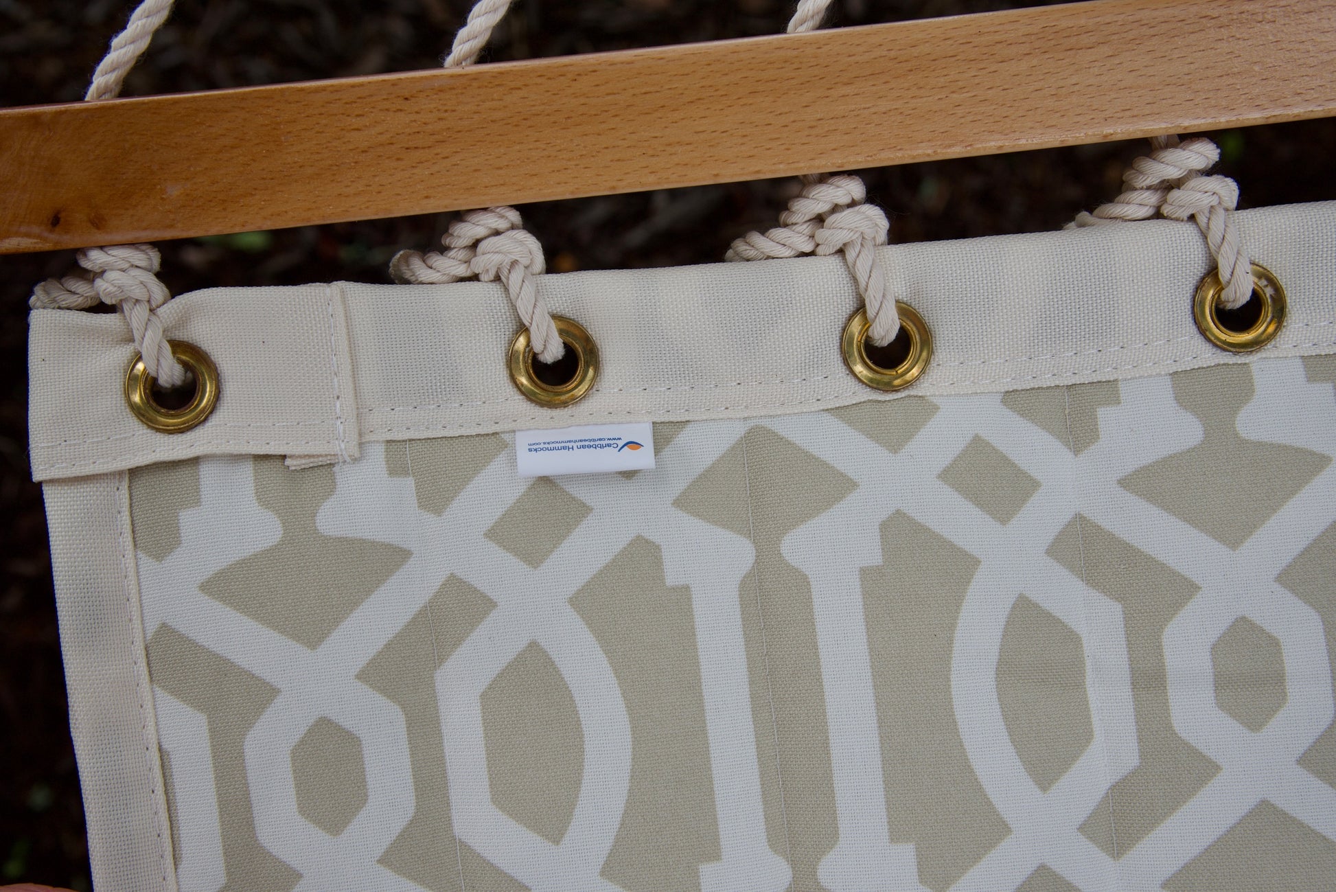 Caribbean Hammocks label and brass roll-rimmed grommets on the reinforced edge of a beige pattern Island Tranquility hammock