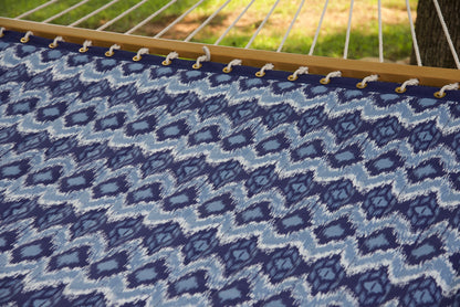 Polyester end cords fanning from the wood spreader bar of a blue wave Island Tranquility hammock