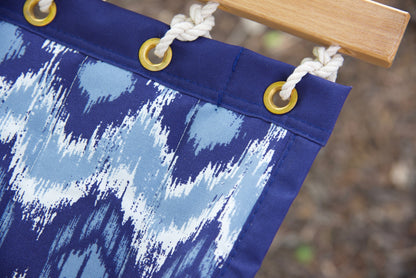 Corner of a blue wave Island Tranquility hammock showing the reinforced edge, brass grommets and polyester end cords
