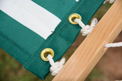 Brass roll-rimmed grommets and polyester end cords on the reinforced edge of a green stripe Island Tranquility hammock