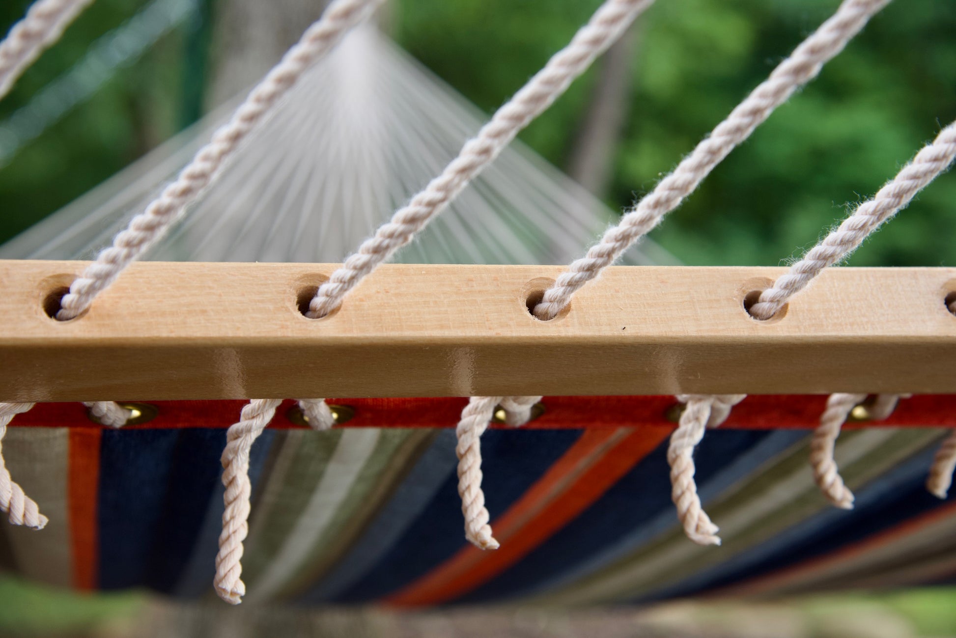Polyester end cords threaded through the drilled wood spreader bar of a multi Island Tranquility hammock