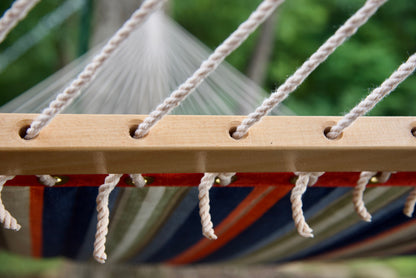 Polyester end cords threaded through the drilled wood spreader bar of a multi Island Tranquility hammock