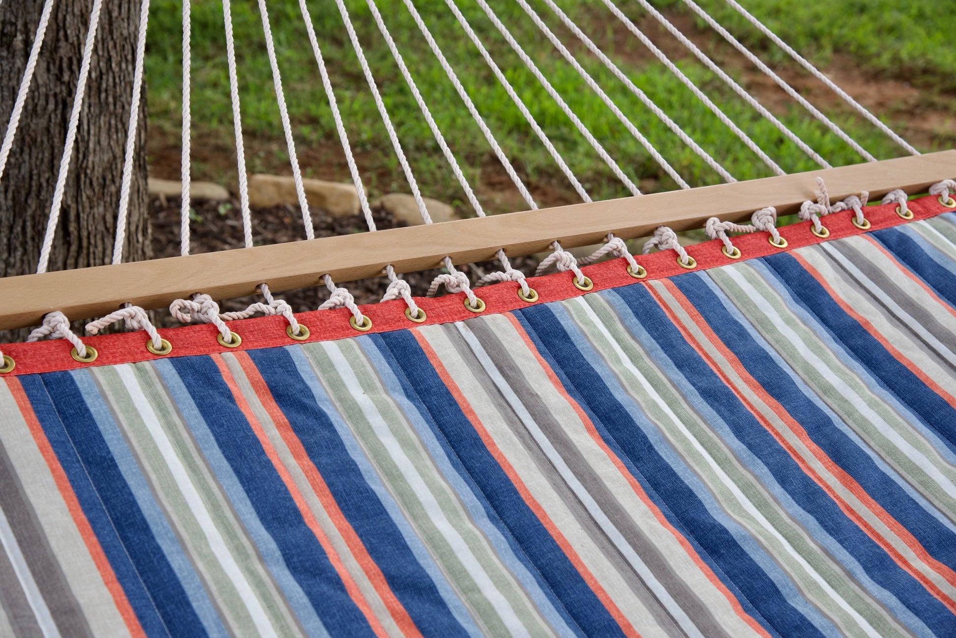 Polyester end cords fanning from the wood spreader bar of a multi Island Tranquility hammock