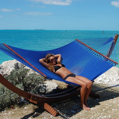 Woman relaxing in the Dark Blue Jumbo Caribbean Hammock on the Wood Arc Hammock Stand