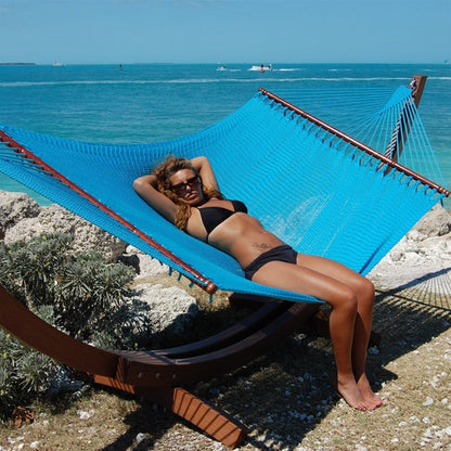 Woman relaxing in the Light Blue Jumbo Caribbean Hammock on the Wood Arc Hammock Stand