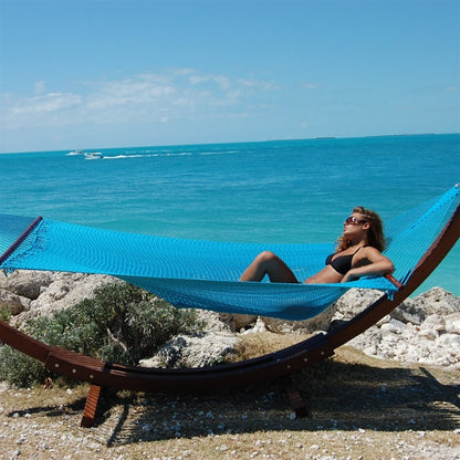 Woman relaxing in the Light Blue Jumbo Caribbean Hammock on the Wood Arc Hammock Stand