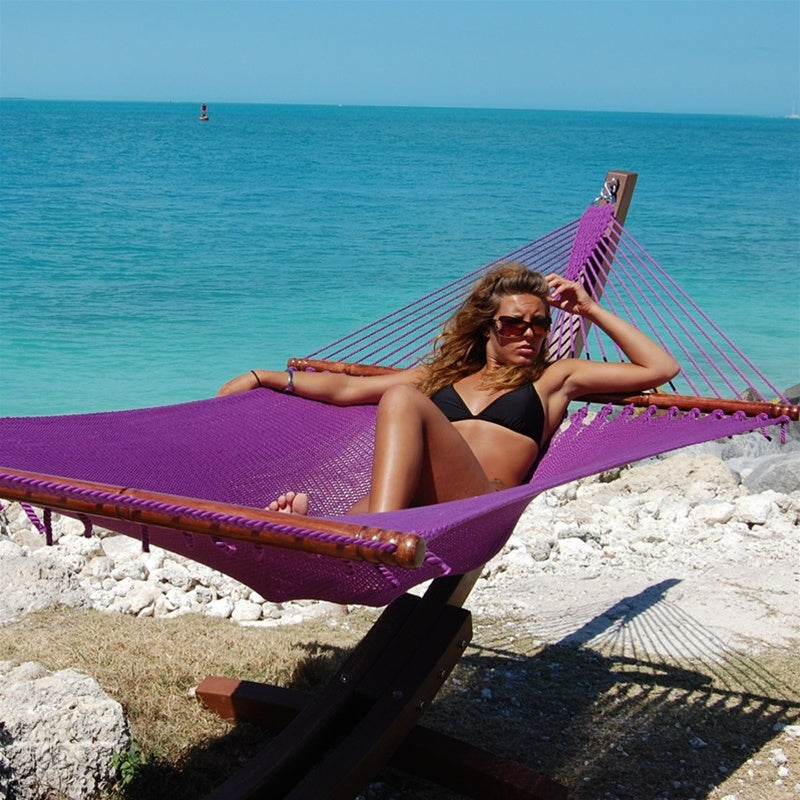 Woman relaxing in the Purple Jumbo Caribbean Hammock on the Wood Arc Hammock Stand