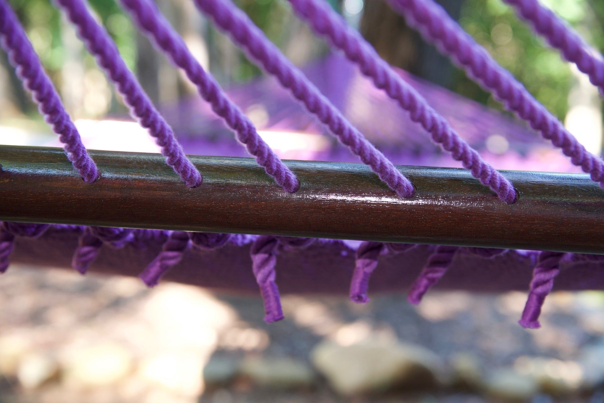 End cords threaded through the drilled hardwood spreader bar of the Purple Jumbo Caribbean Hammock