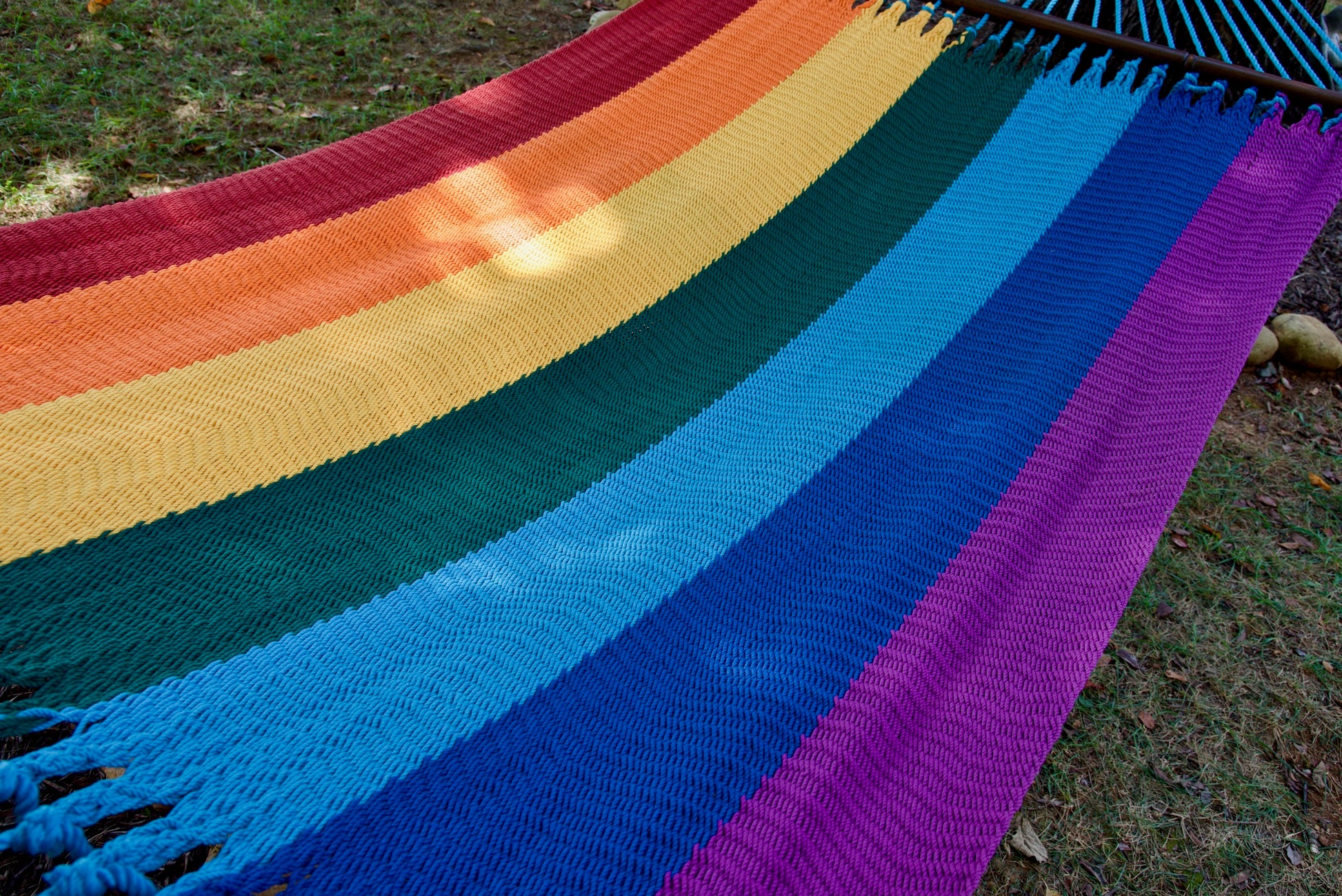 The full striped hand-woven bed of the Rainbow Jumbo Caribbean Hammock seen end to end