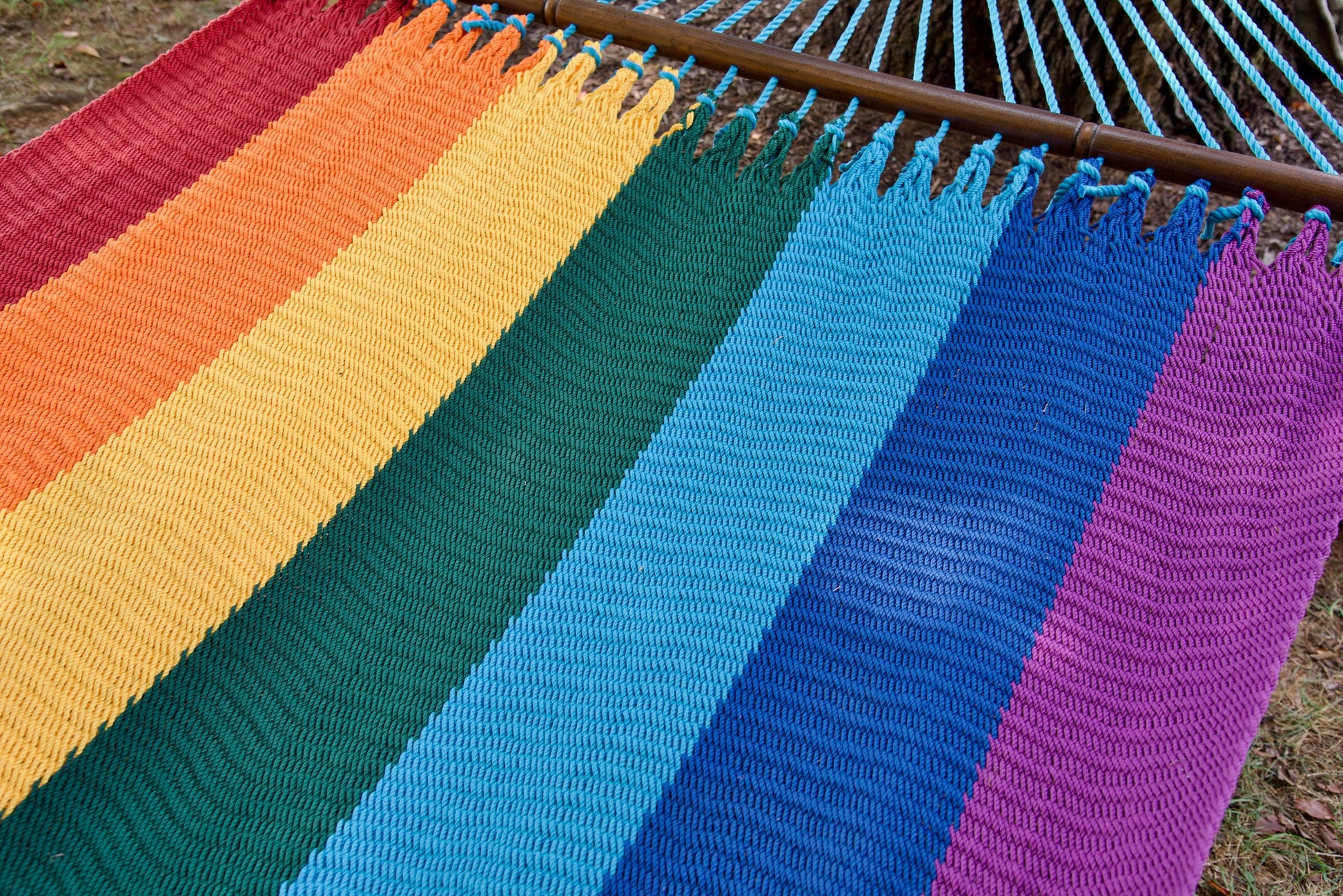 Knotted edge loops and color bands along the spreader bar of the Rainbow Jumbo Caribbean Hammock