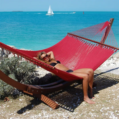 Woman relaxing in the Red Jumbo Caribbean Hammock on the Wood Arc Hammock Stand