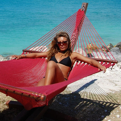 Woman relaxing in the Red Jumbo Caribbean Hammock on the Wood Arc Hammock Stand